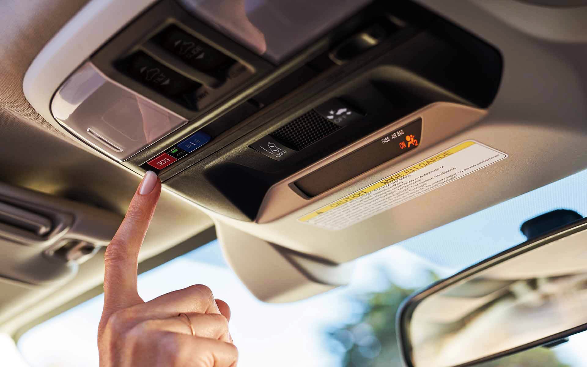 A finger pressing the Crosstrek Hybrid's SOS emergency assistance button | Dalton Subaru in National City CA