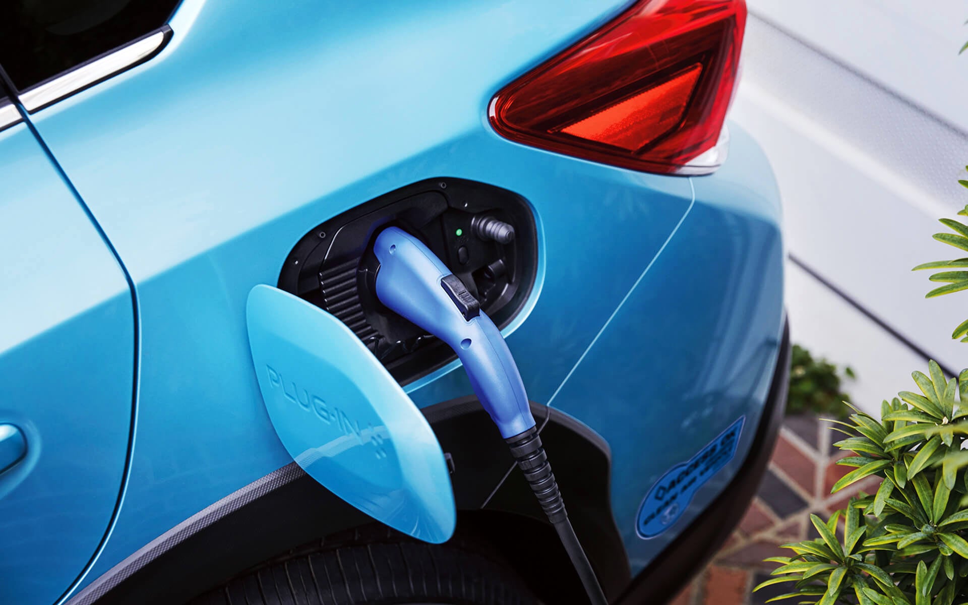 A close-up of the Subaru Crosstrek Hybrid's charging port with charging cable plugged in | Dalton Subaru in National City CA