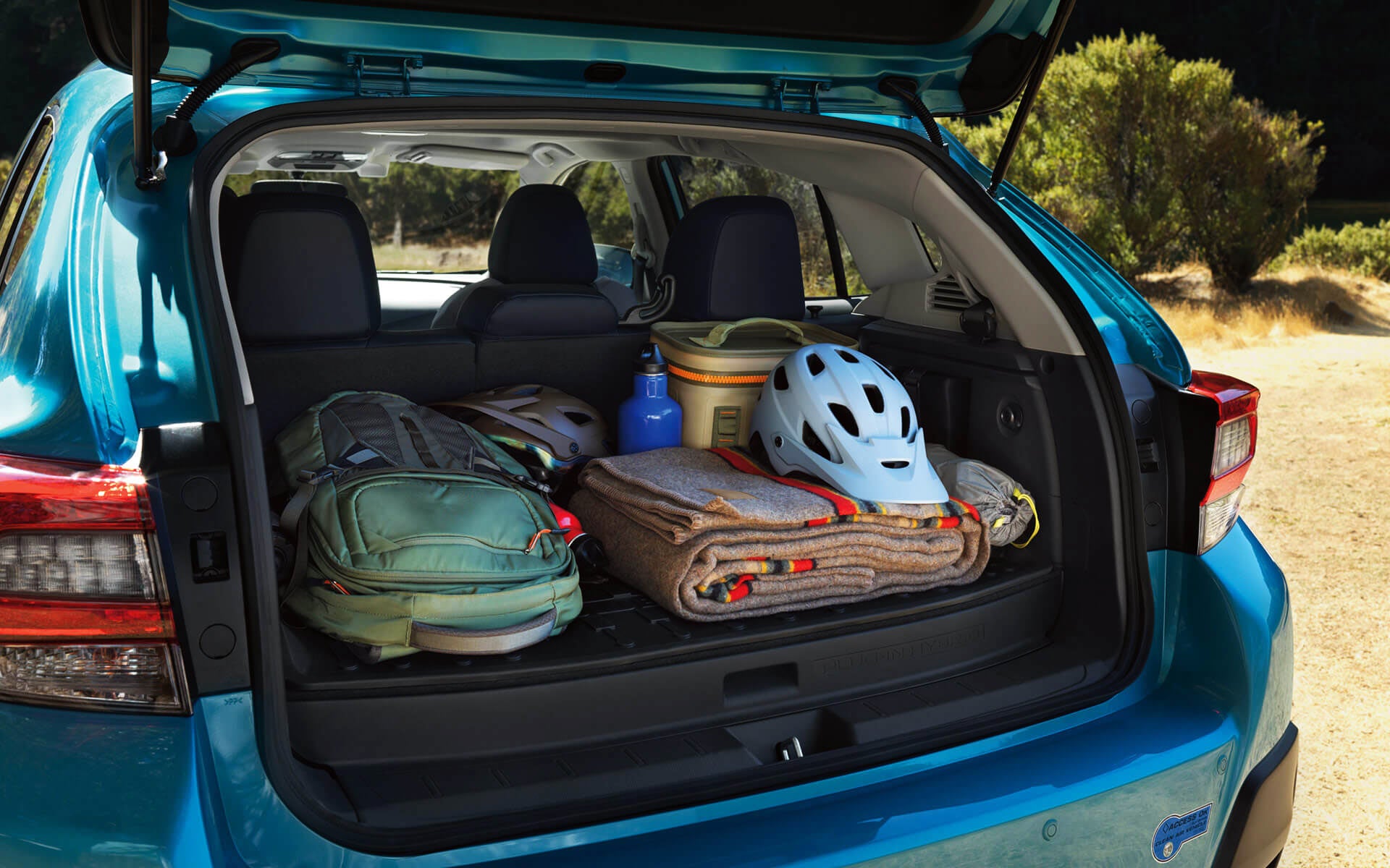 A backpack, blanket, and bike helmet in the rear cargo area of a Crosstrek Hybrid | Dalton Subaru in National City CA
