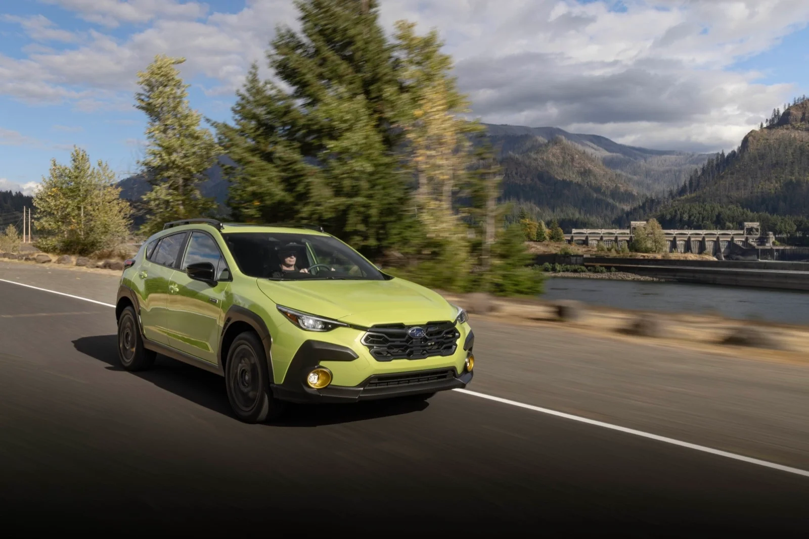Green 2026 Subaru Crosstrek Hybrid driving on a mountain road — Consumer Reports' Top Subcompact SUV for 2026