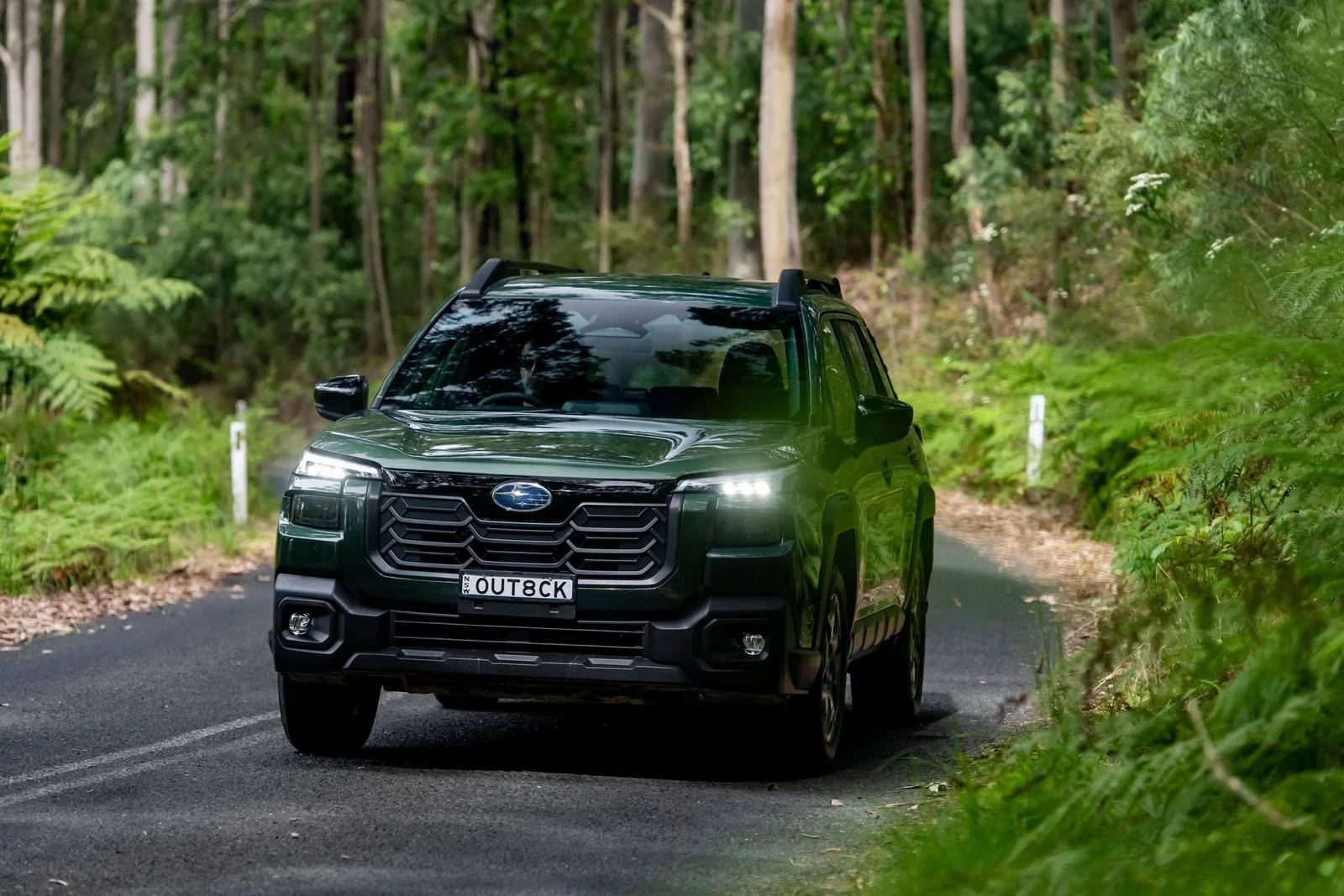 A dark green Subaru Forester on a forest road.