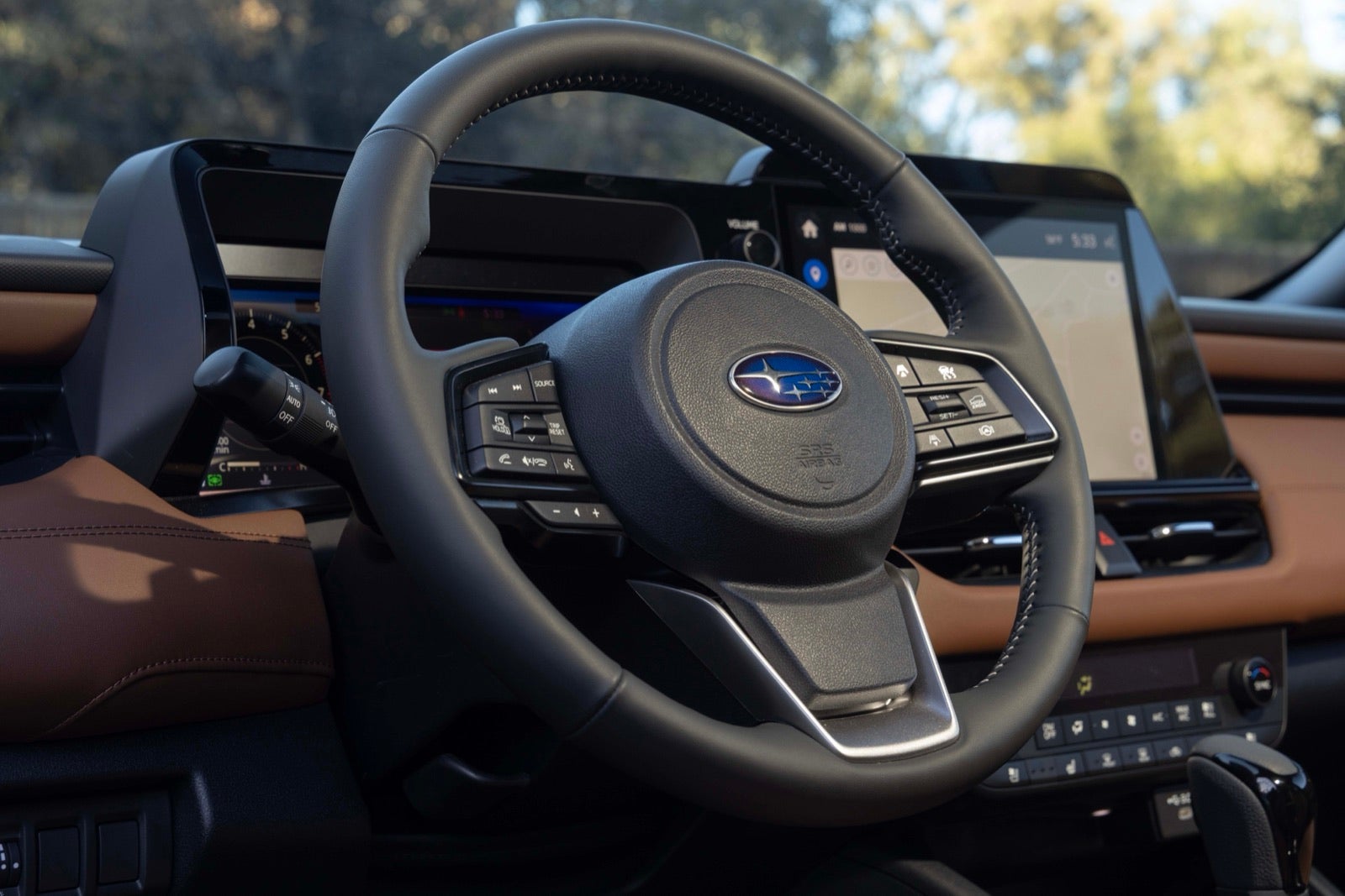 The steering wheel and dashboard display inside a 2026 Outback with brown leather.
