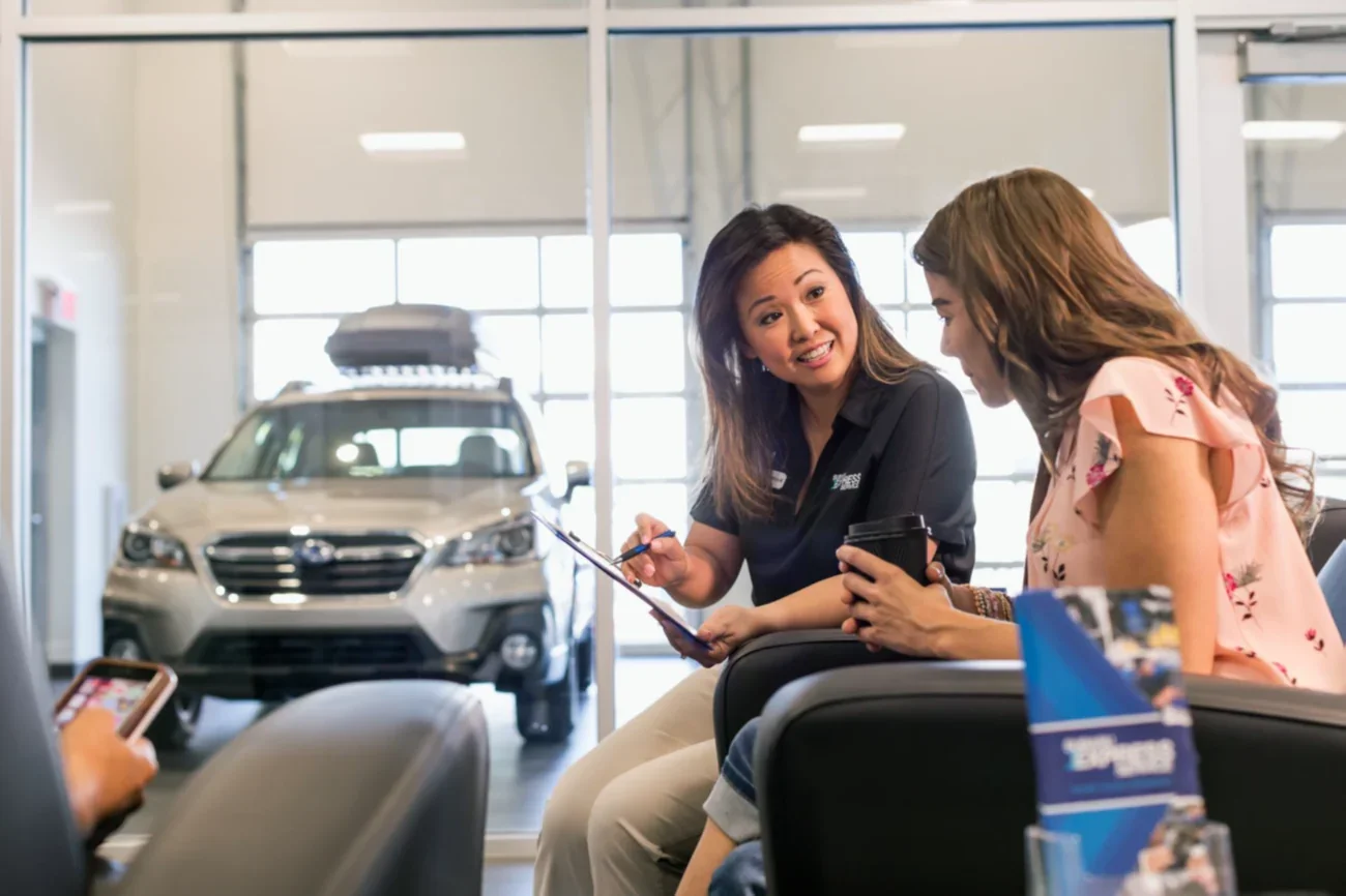 A service advisor going over paperwork with a customer in the lounge.