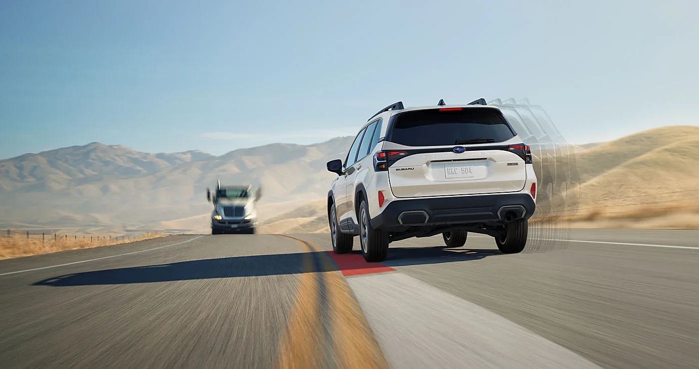 A white 2026 Subaru Forester Hybrid on a desert highway.