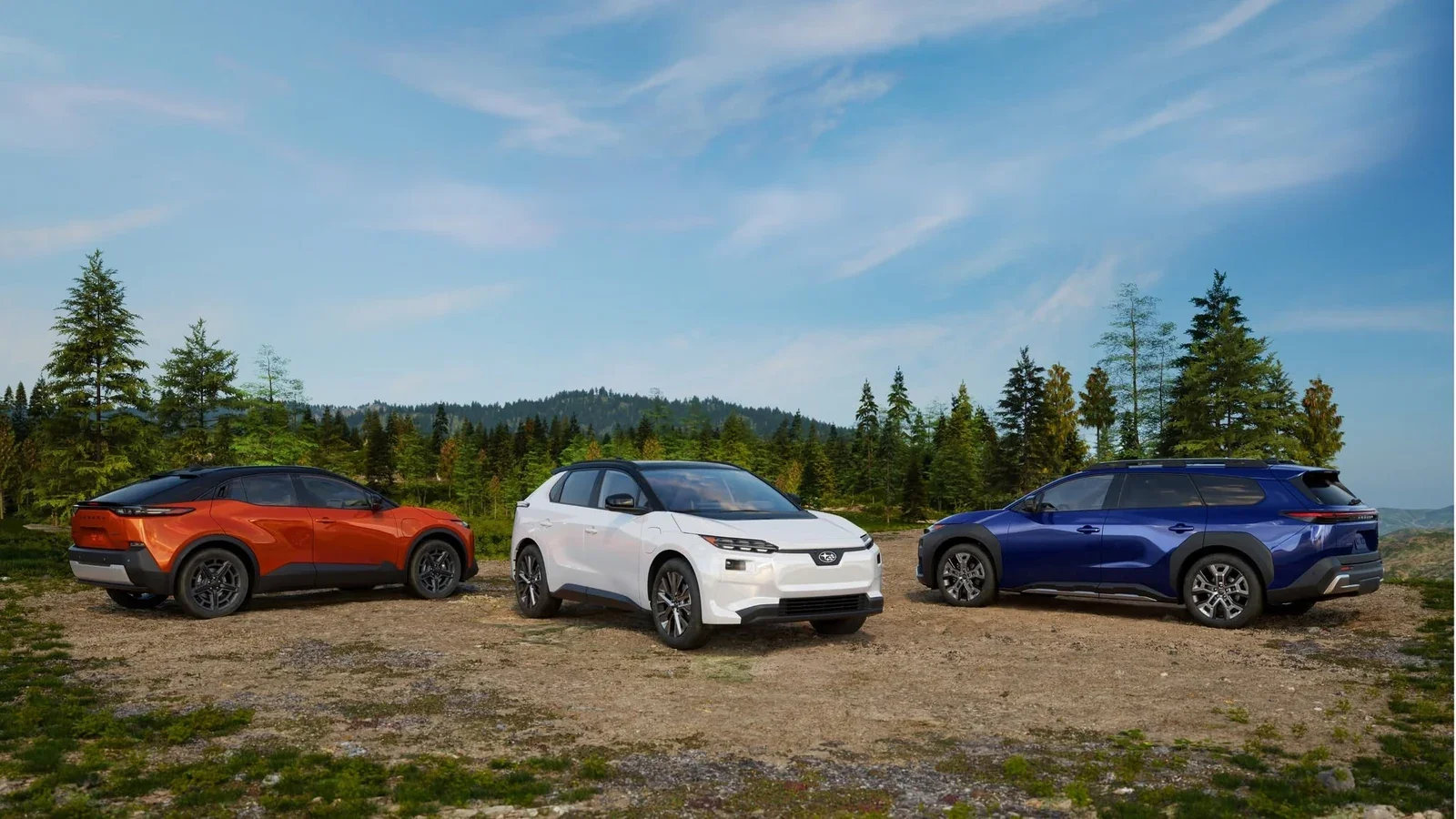 Three Subaru electric SUVs, in orange, white and blue, parked in a clearing ringed by pines.